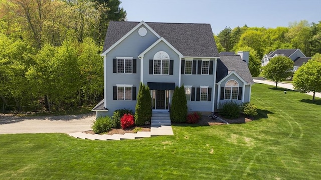 view of front of property featuring a front yard and roof with shingles