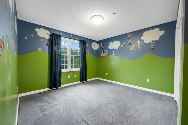 carpeted spare room featuring baseboards