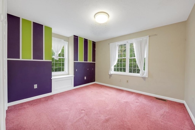 carpeted spare room featuring baseboards