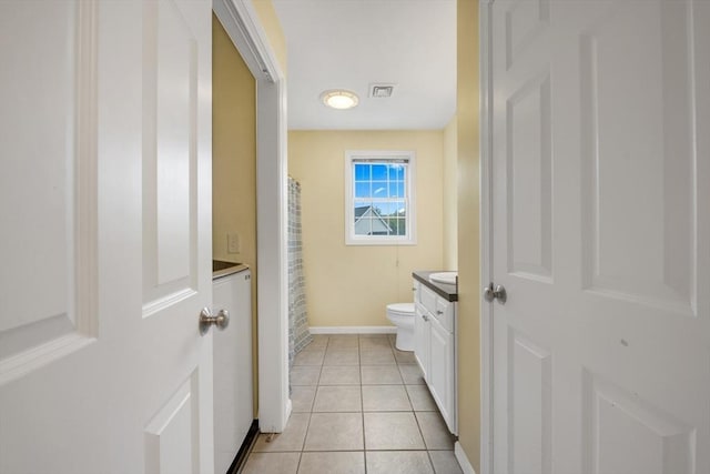 full bathroom featuring vanity, tile patterned flooring, toilet, washer / clothes dryer, and baseboards