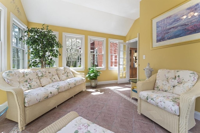 sunroom with tile patterned flooring, vaulted ceiling, and baseboards