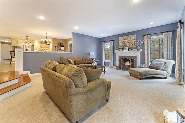 living room featuring recessed lighting, a chandelier, light colored carpet, and a healthy amount of sunlight