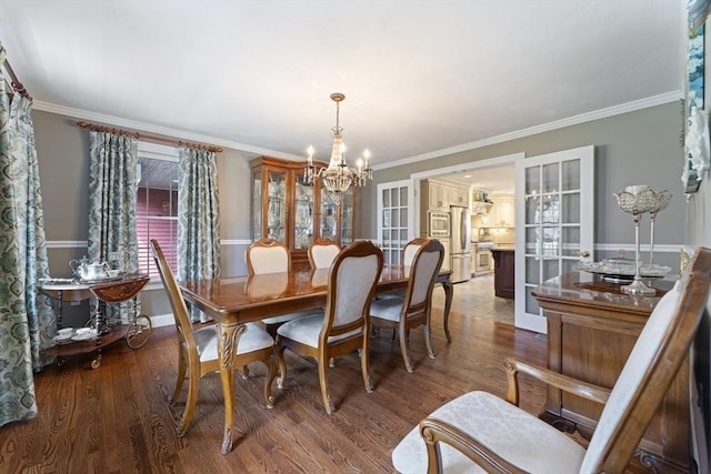 dining room featuring ornamental molding, an inviting chandelier, and wood finished floors