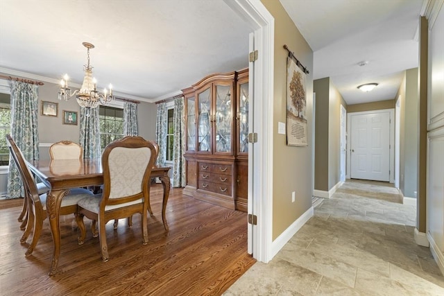 dining space featuring an inviting chandelier, stone finish flooring, a barn door, and baseboards