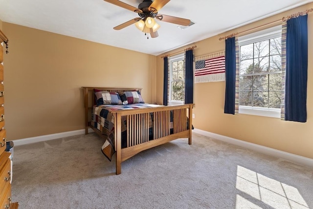 carpeted bedroom featuring ceiling fan and baseboards