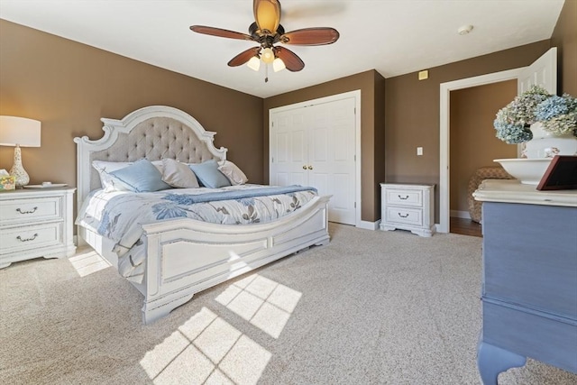 carpeted bedroom with ceiling fan, baseboards, and a closet