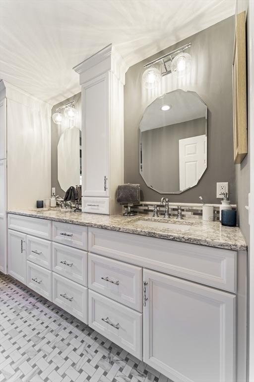 full bathroom with double vanity and a sink