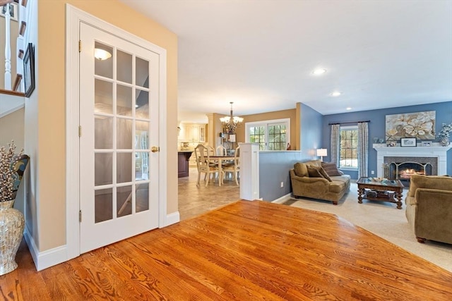 living room with recessed lighting, a notable chandelier, baseboards, and a fireplace