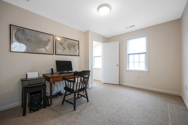 carpeted office space featuring visible vents and baseboards