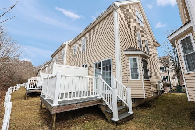 rear view of property featuring a wooden deck and a yard