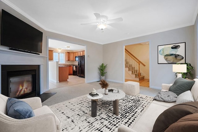 living area with baseboards, a fireplace with flush hearth, stairs, ornamental molding, and light carpet