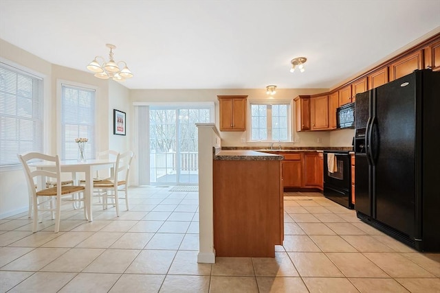 kitchen featuring dark countertops, black appliances, light tile patterned flooring, and brown cabinetry