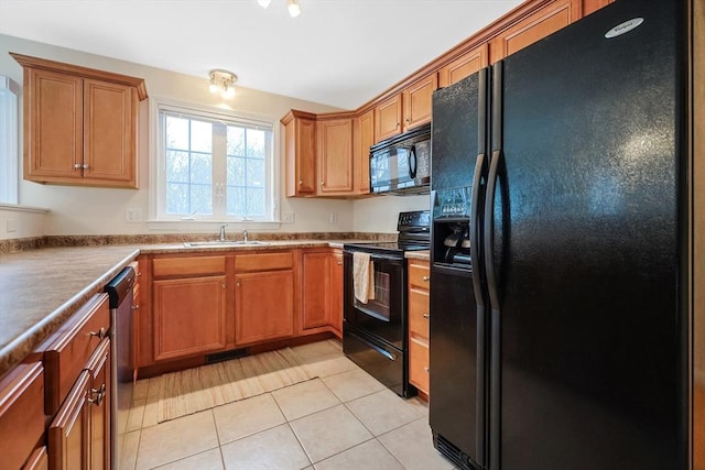 kitchen with light tile patterned floors, brown cabinetry, visible vents, a sink, and black appliances