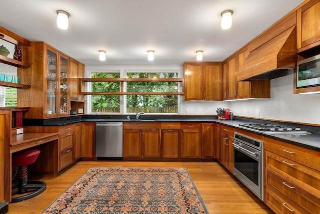 kitchen featuring appliances with stainless steel finishes, open shelves, a sink, and brown cabinetry