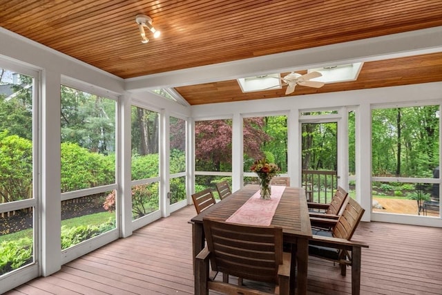 sunroom with a skylight, a deck, wooden ceiling, hardwood / wood-style floors, and vaulted ceiling