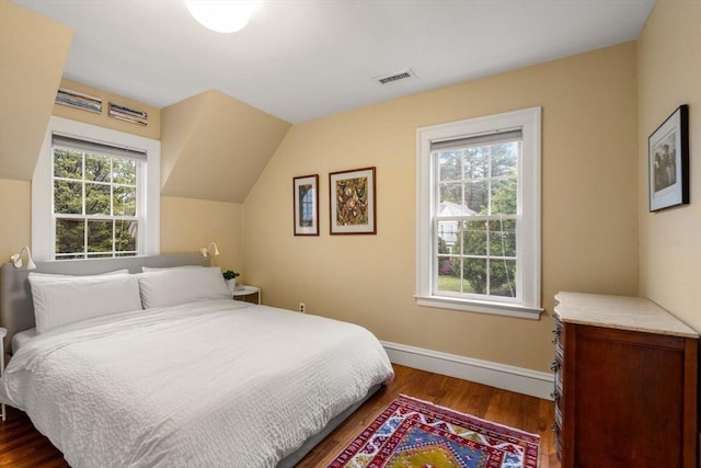bedroom with dark wood-type flooring and baseboards