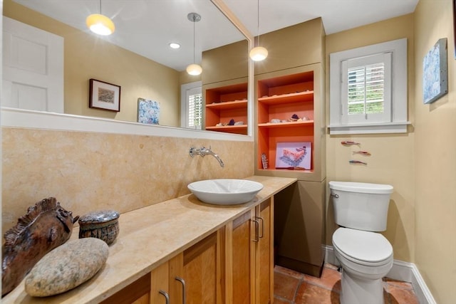 bathroom with decorative backsplash, toilet, vanity, and baseboards