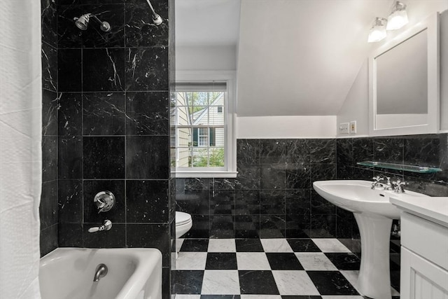full bath with tile walls, toilet, shower / bathtub combination, and lofted ceiling