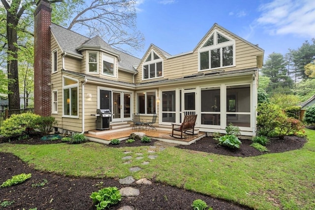 back of property with a chimney, a sunroom, french doors, and a patio