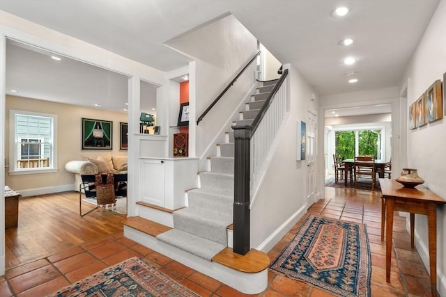 stairs with baseboards and recessed lighting