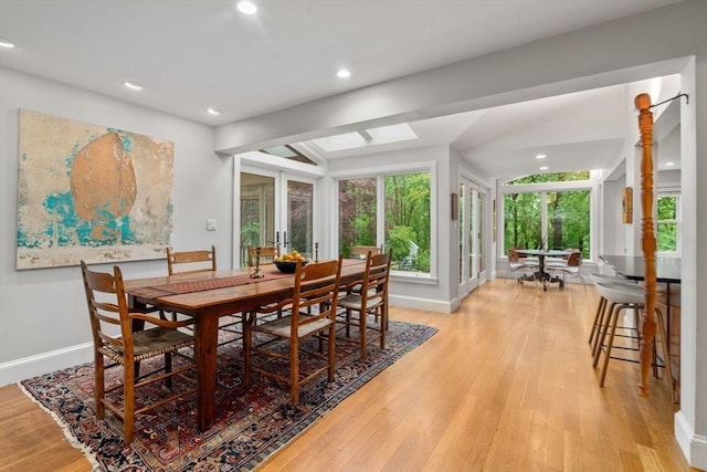 dining space featuring light wood-type flooring, baseboards, recessed lighting, and a skylight