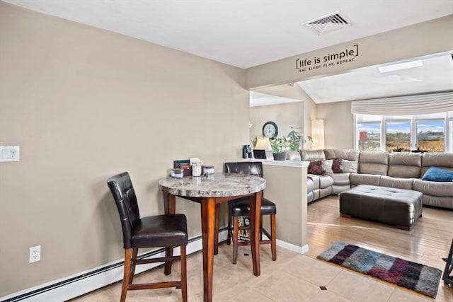 dining area with light hardwood / wood-style flooring, baseboard heating, and lofted ceiling