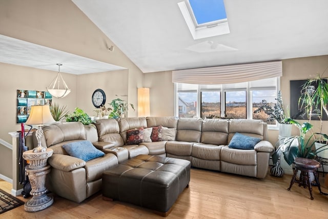 living room featuring high vaulted ceiling, a skylight, and light hardwood / wood-style flooring