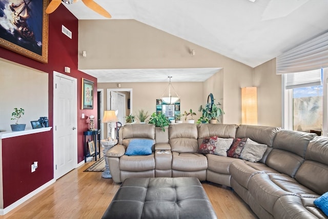 living room with ceiling fan, light hardwood / wood-style flooring, a healthy amount of sunlight, and vaulted ceiling