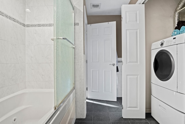 laundry room featuring washer / clothes dryer and dark tile patterned floors