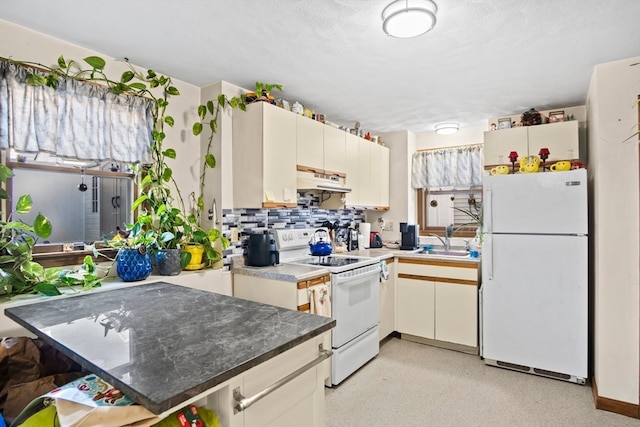 kitchen with decorative backsplash, white appliances, and sink