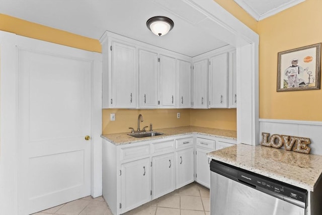 kitchen featuring light stone countertops, light tile patterned flooring, a sink, white cabinets, and stainless steel dishwasher