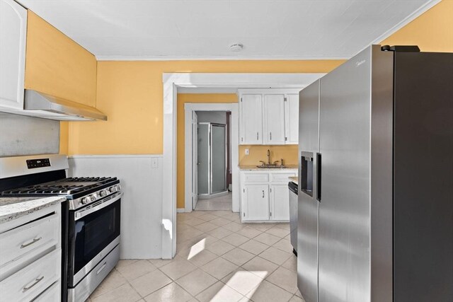 kitchen with a sink, stainless steel appliances, range hood, and white cabinetry