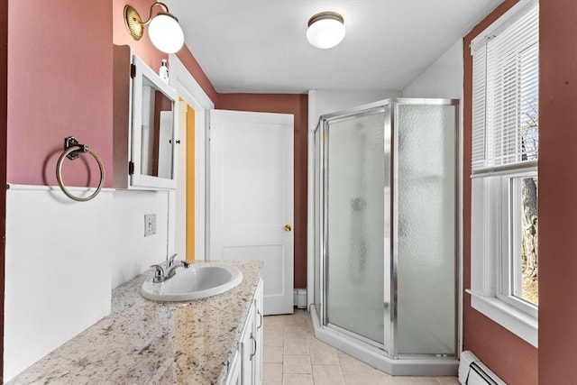 full bathroom with vanity, baseboard heating, a shower stall, and tile patterned flooring