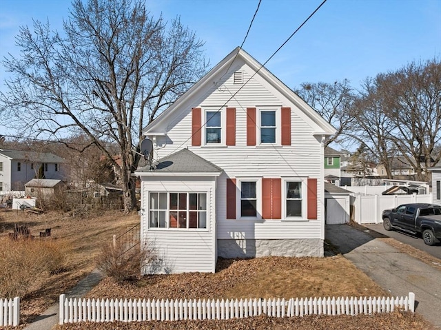 traditional-style home featuring driveway and fence