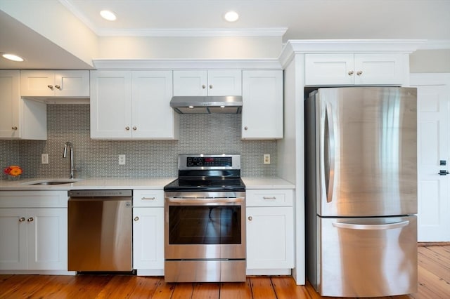 2 Court St Unit 3, Newburyport, MA 01950 - kitchen with stainless steel appliances, under cabinet range hood, light countertops, ornamental molding, and light wood-type flooring