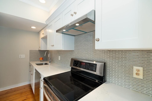 2 Court St Unit 3, Newburyport, MA 01950 - kitchen with stainless steel appliances, under cabinet range hood, ornamental molding, white cabinets, and decorative backsplash