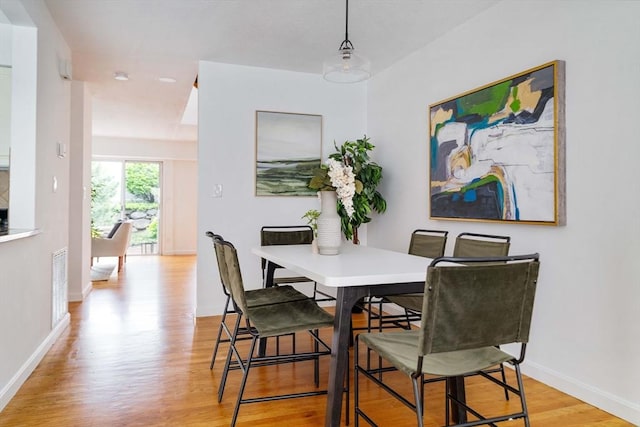 dining room with light wood-style floors and baseboards