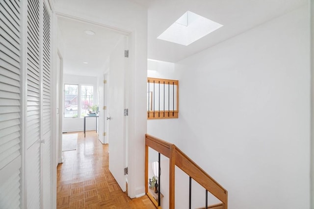 corridor with a skylight, baseboards, and recessed lighting