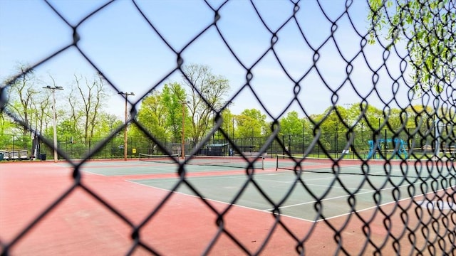 view of tennis court featuring fence