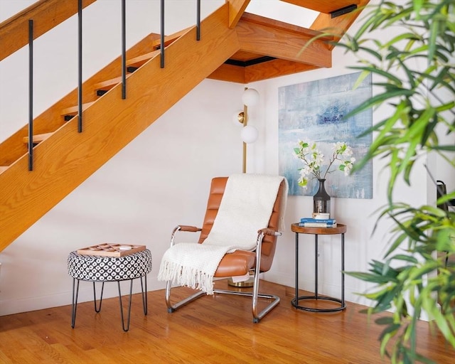 sitting room with wood finished floors, baseboards, and a skylight