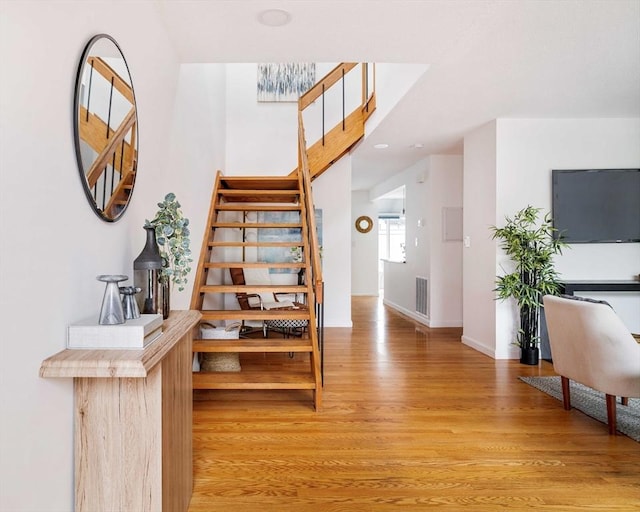 staircase with wood finished floors and baseboards