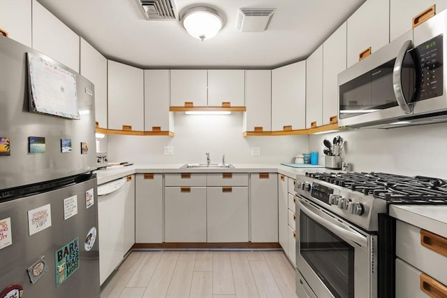 kitchen featuring sink, stainless steel appliances, and white cabinetry