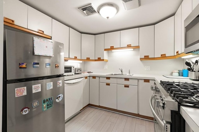 kitchen featuring sink, appliances with stainless steel finishes, and white cabinetry