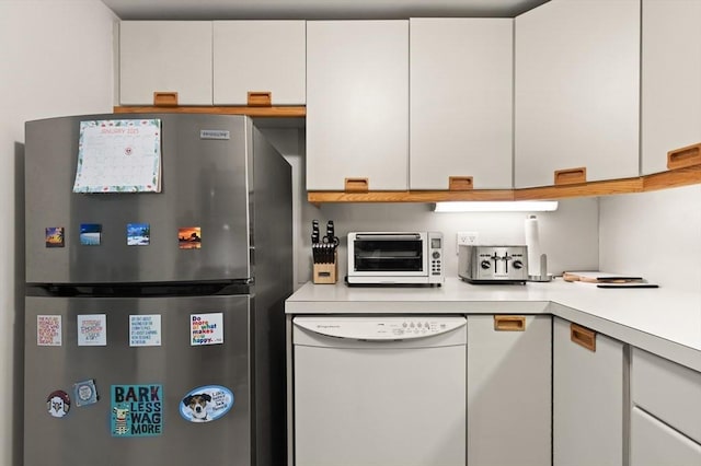 kitchen featuring white cabinets, dishwasher, and stainless steel refrigerator