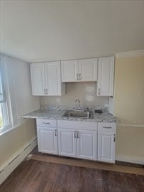 kitchen with white cabinets, light stone countertops, baseboard heating, dark hardwood / wood-style flooring, and sink