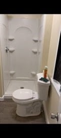 bathroom featuring walk in shower and toilet