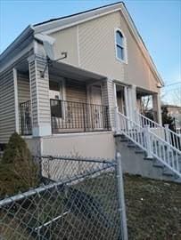 view of home's exterior featuring covered porch, a fenced front yard, and stairway