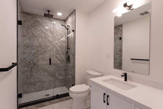 bathroom featuring vanity, an enclosed shower, and toilet