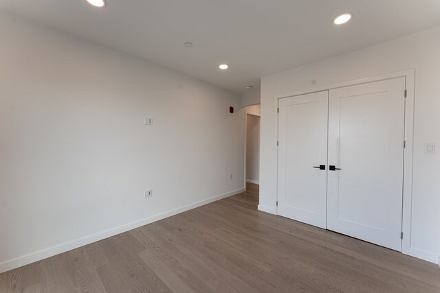 unfurnished bedroom with a closet and light hardwood / wood-style floors