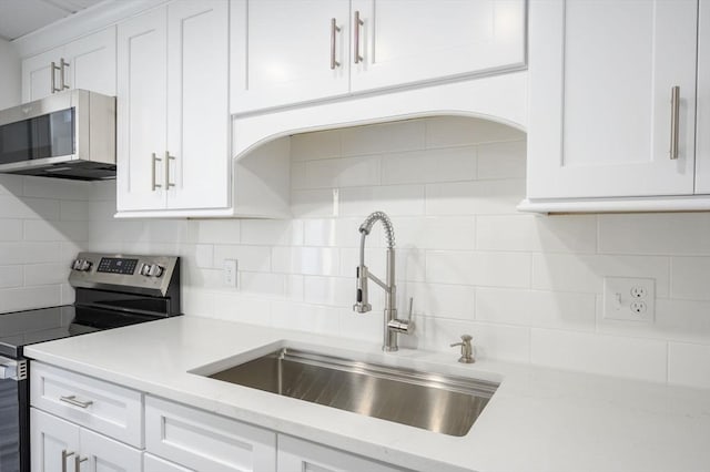 kitchen with white cabinetry, sink, tasteful backsplash, and stainless steel appliances